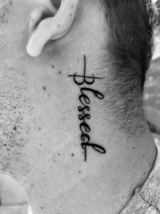 tatuagem com frase blessed no pescoço