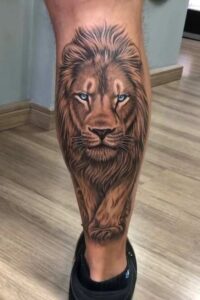 tatuagem de leão colorida masculina na panturilha