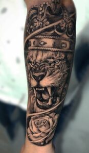 tatuagem de leao com coroa no antebraço