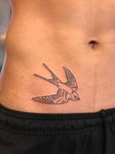 tatuagem de passaro na cintura masculina