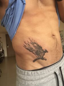 tatuagem de passaro na cintura masculina