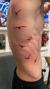 tatuagem de pássaros na costela masculina